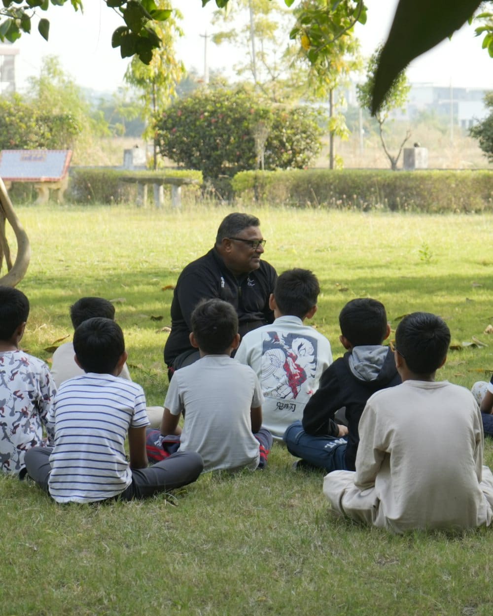 Un adulto comparte una historia con un grupo de niños al aire libre.
